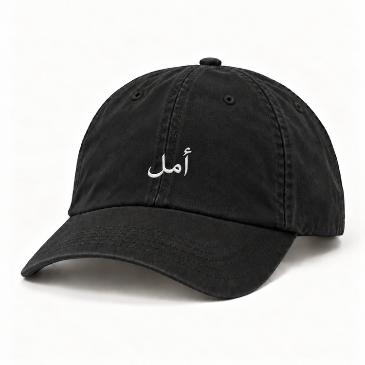 Front view of black Amal Hope cap with white Arabic embroidery